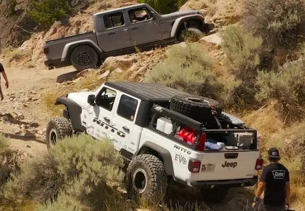 2 jeep gladiators rock climbing on a hill