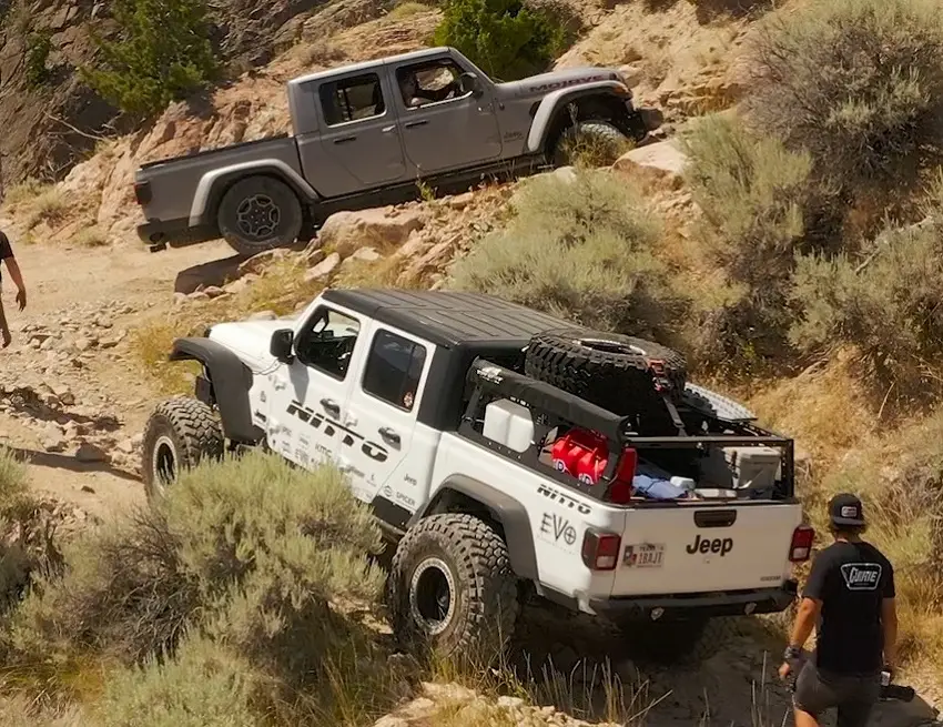 2 jeep gladiators rock climbing on a hill